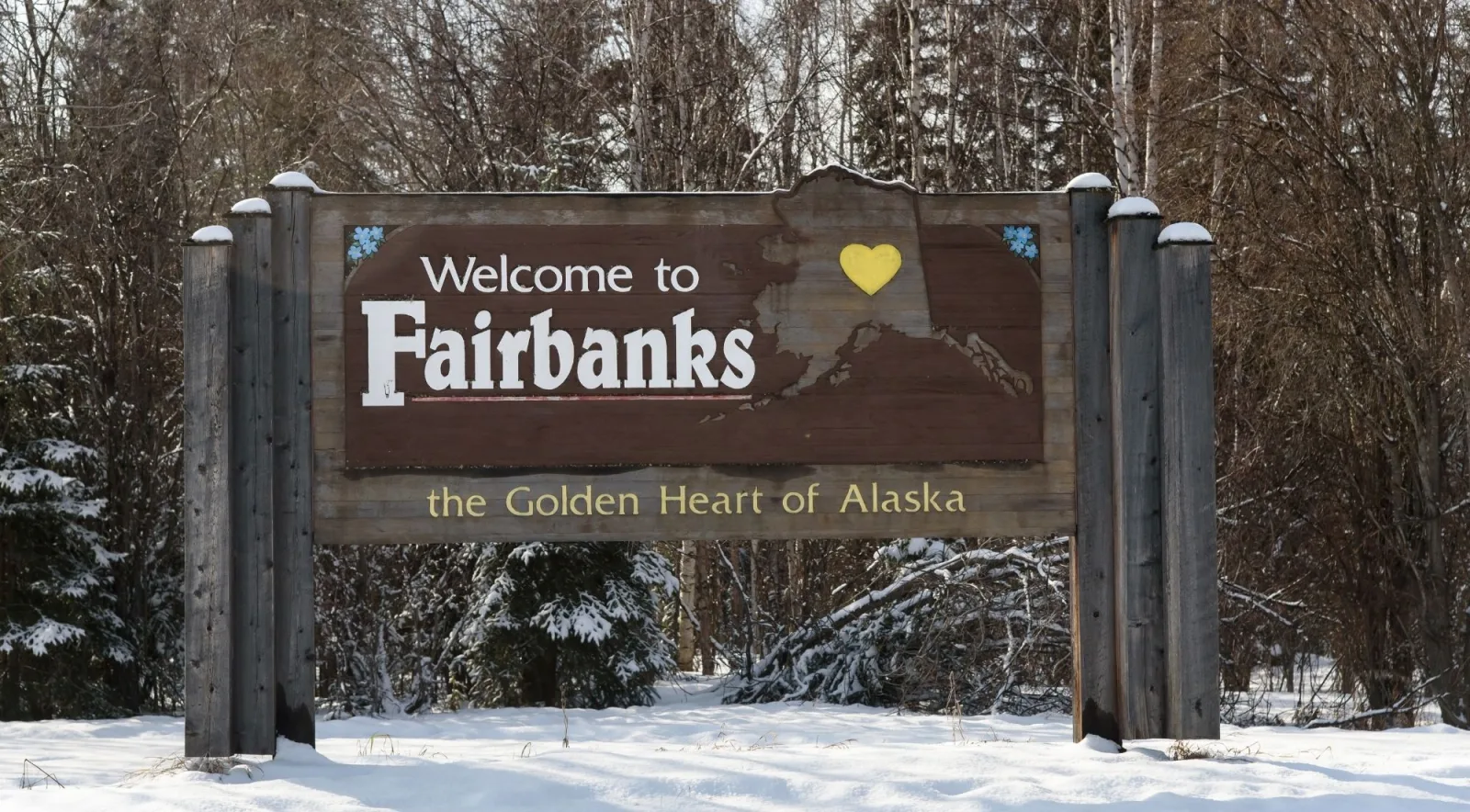 Wooden Welcome to Fairbanks, the Golden Heart of Alaska sign in deep snow