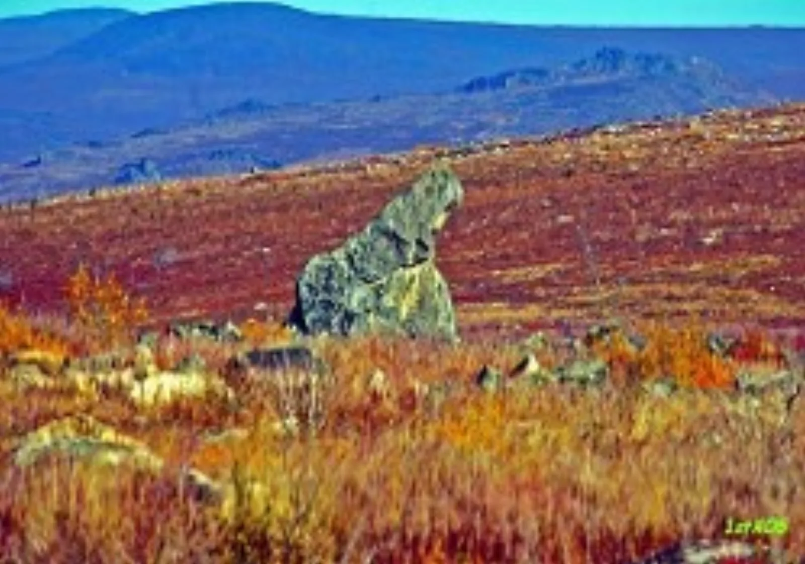 Granite tor on the Finger Mountain plateau above red and gold autumn tundra, hills in the distance