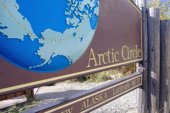 Close-up of the Arctic Circle sign globe and the latitude 66 degrees 33 minutes lettering