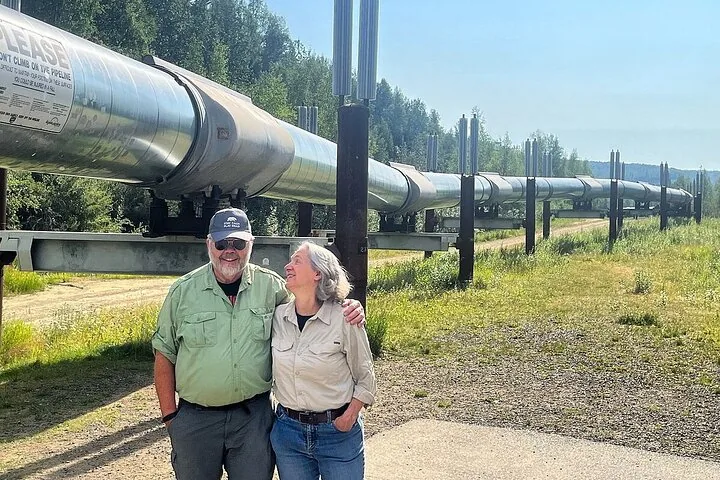 Couple posing in front of the Trans-Alaska Pipeline at the viewing stop north of Fairbanks